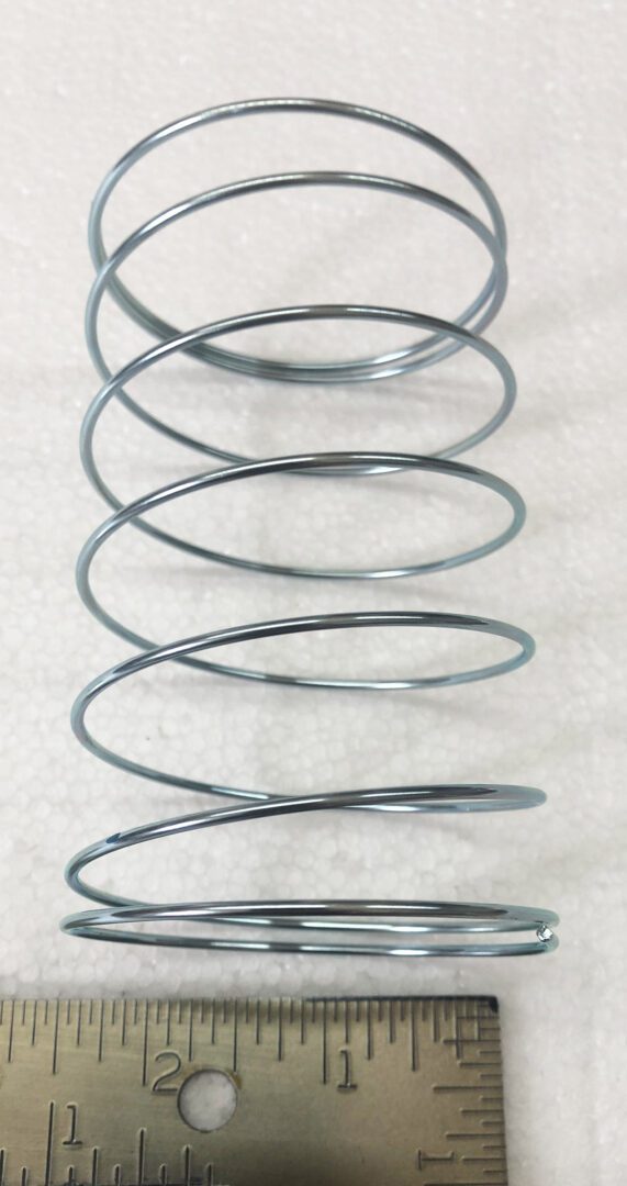 A metal coil sitting on top of a white surface.