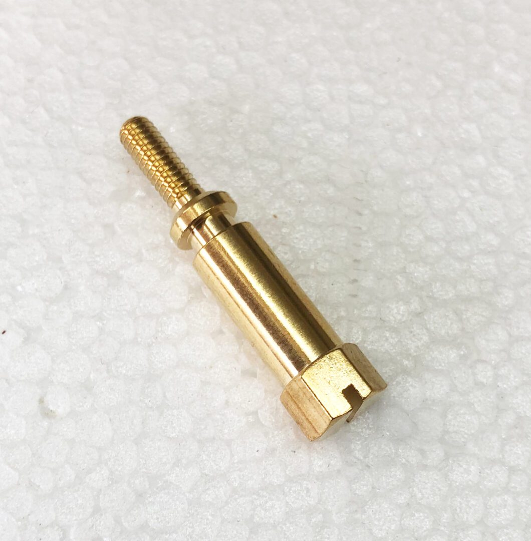 A close up of the side of a gold colored pin.