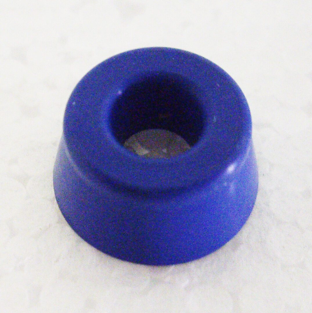 A blue rubber washer sitting on top of a table.