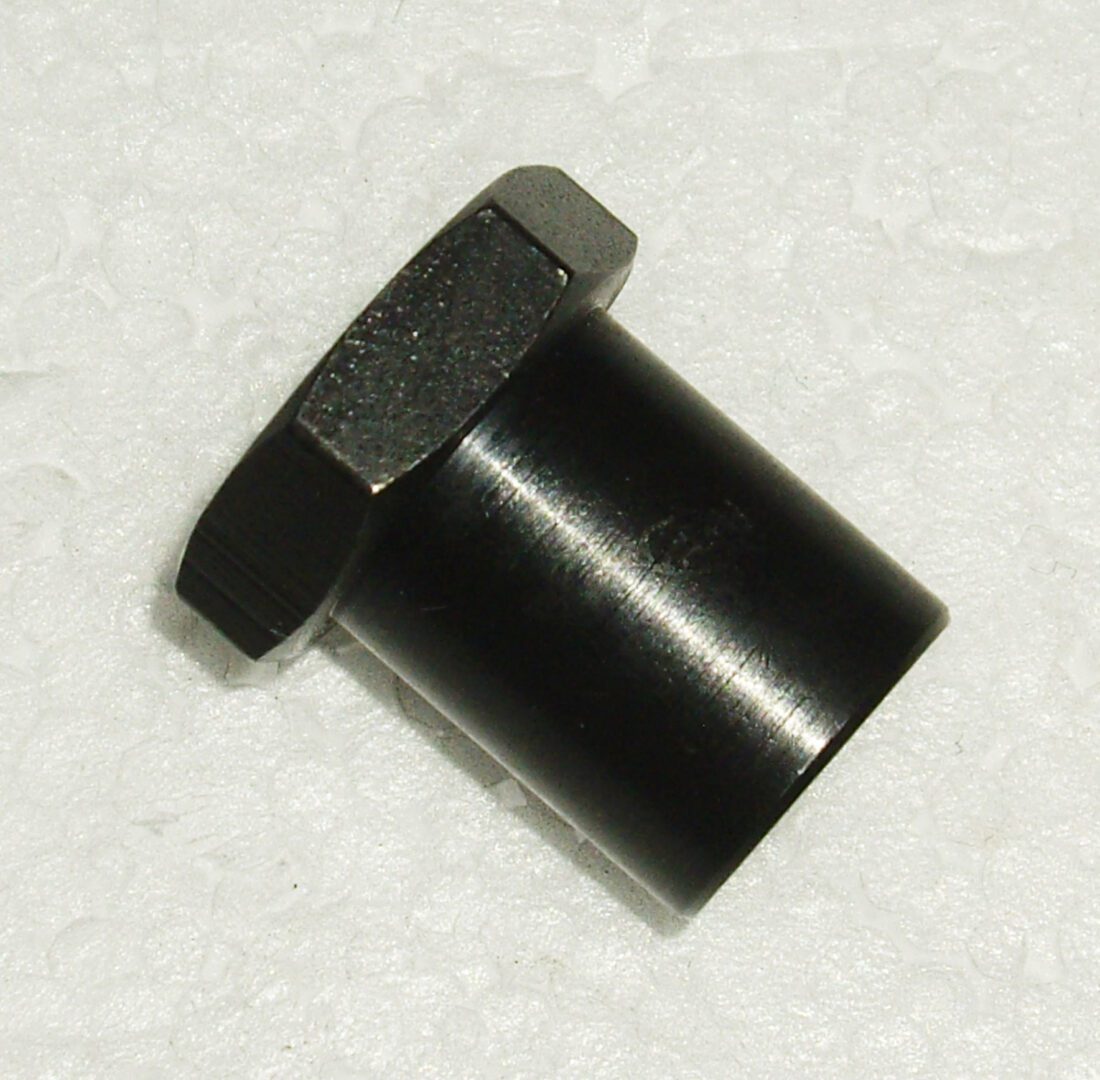 A black nut and bolt sitting on top of a white surface.