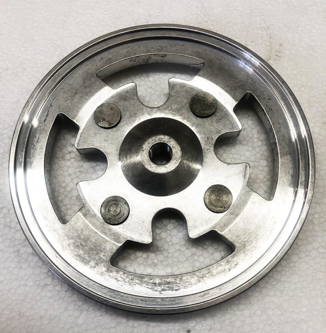 A metal wheel with six holes on it.