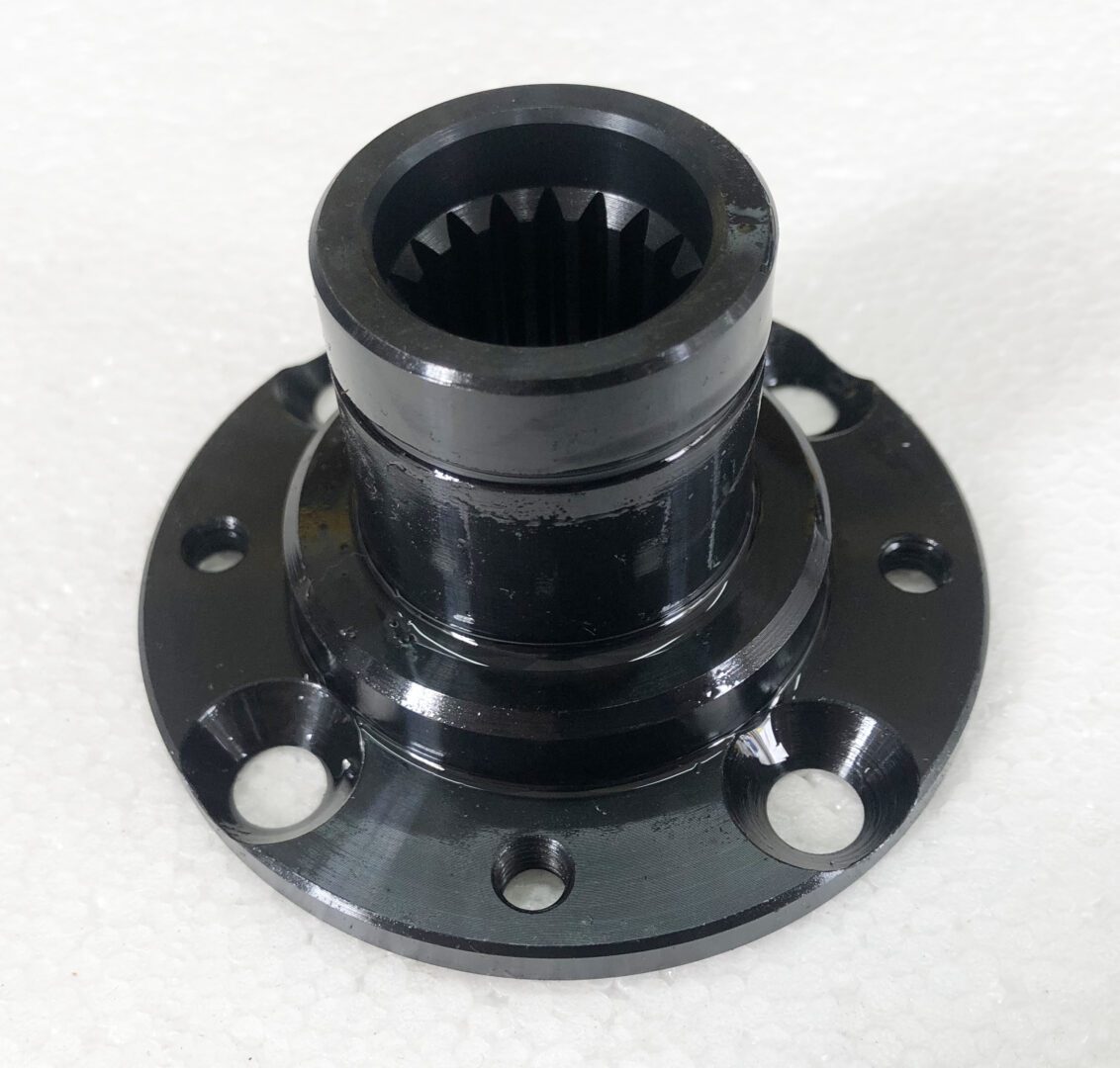 A black metal object with four holes on top of it.