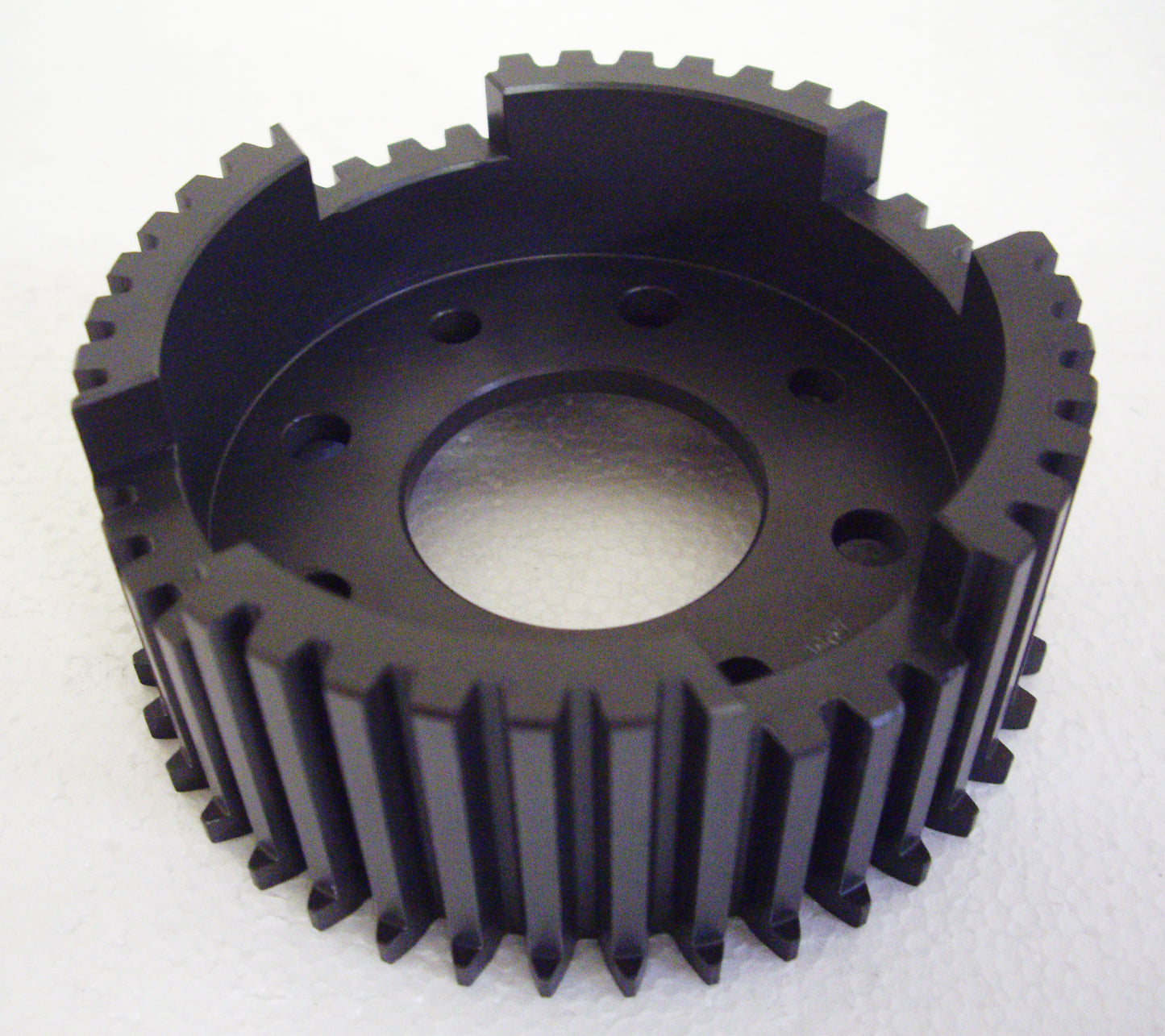 A black plastic gear with a hole in it.