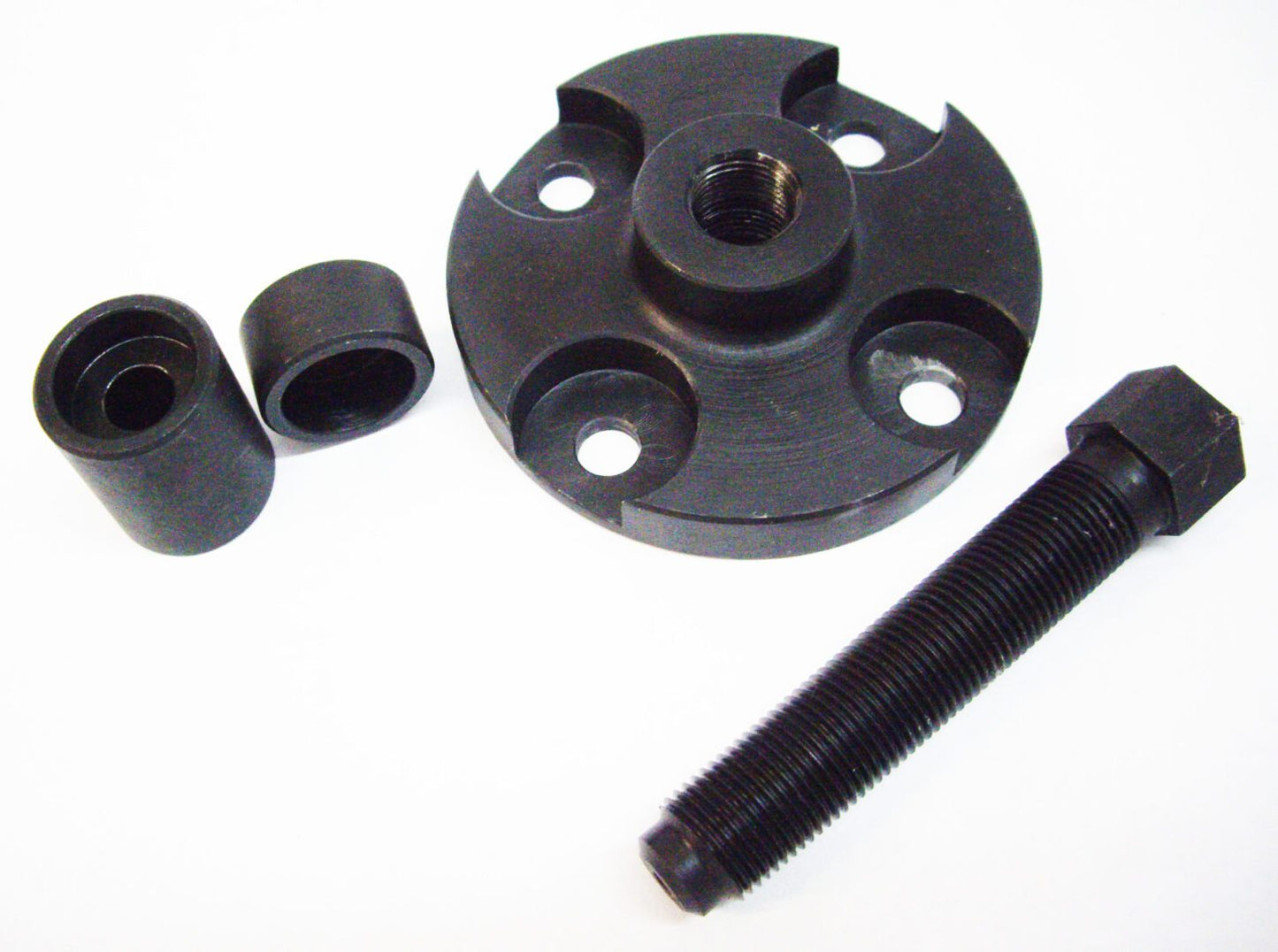 A black plastic object with two small nuts and one large nut.