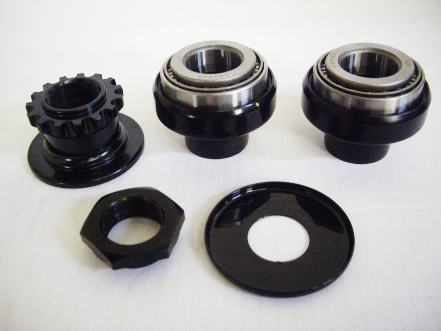 A set of three black bicycle hubs and two black ones.