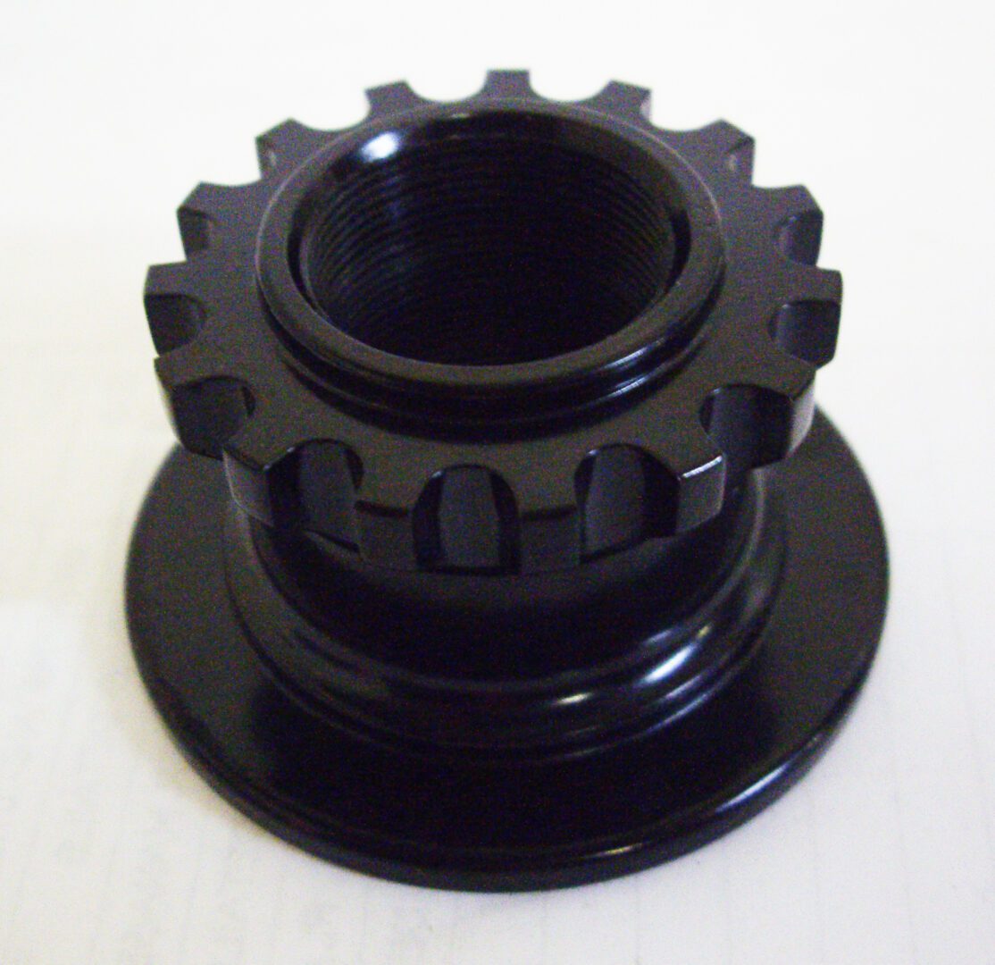 A black plastic object with a large gear on top of it.