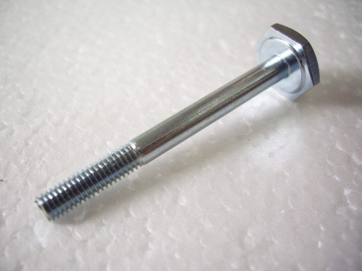 A metal bolt with a nut and screw attached to it.