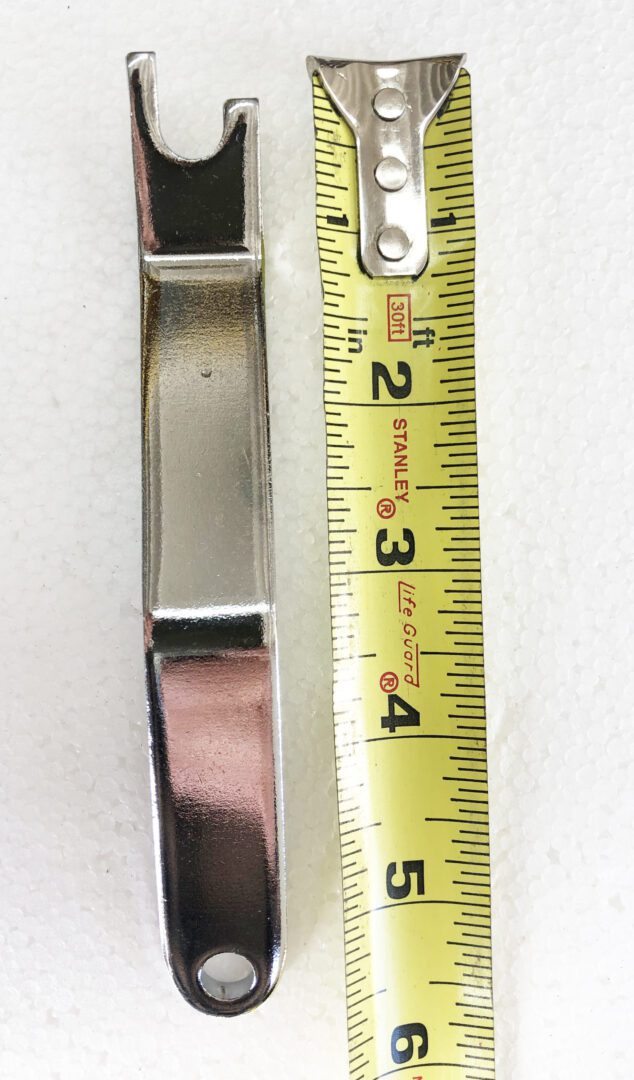 A metal ruler is next to the handle of a bracelet.