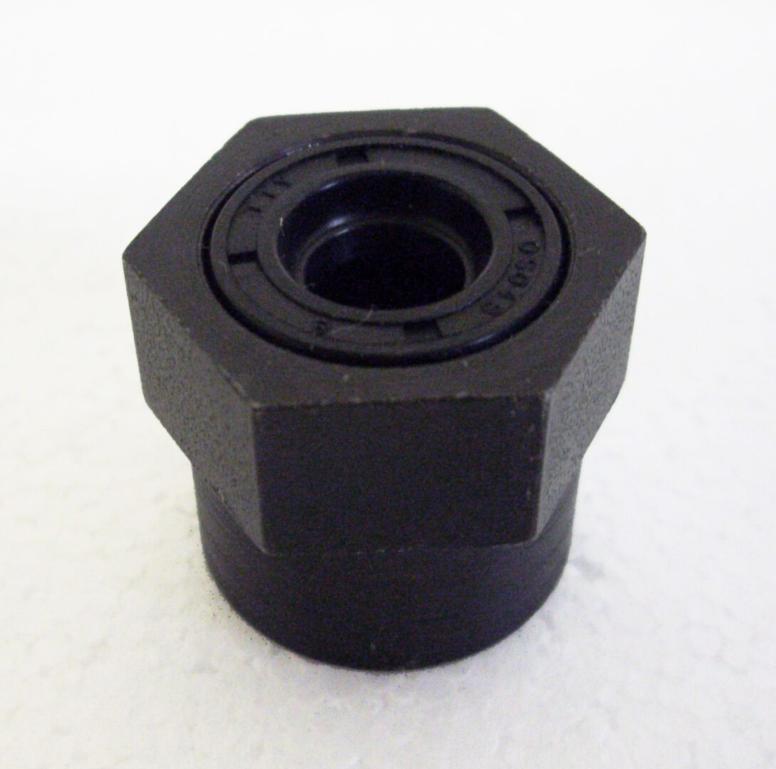 A black nut with a hole in it.