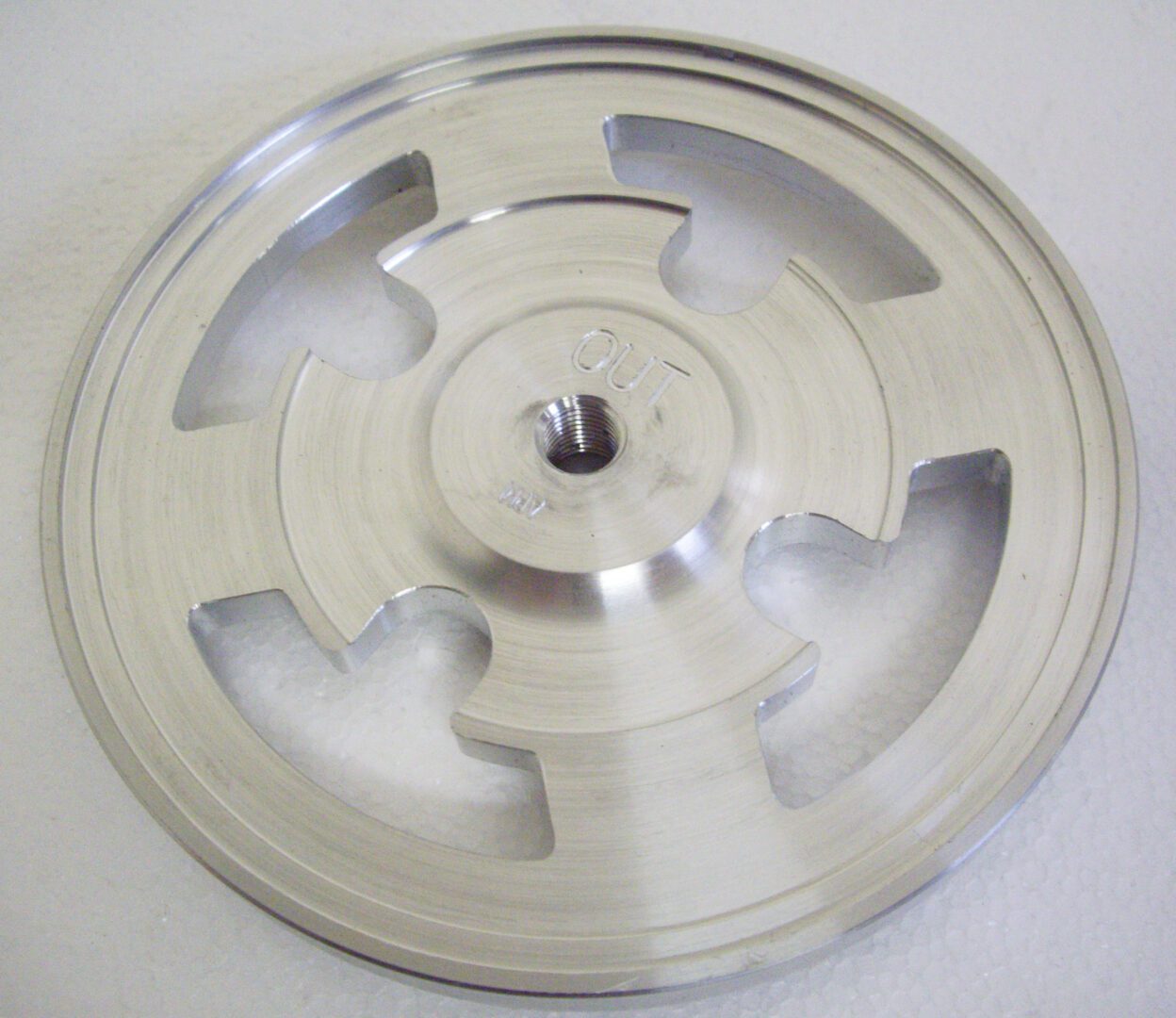 A silver disc with five pieces of metal on it.