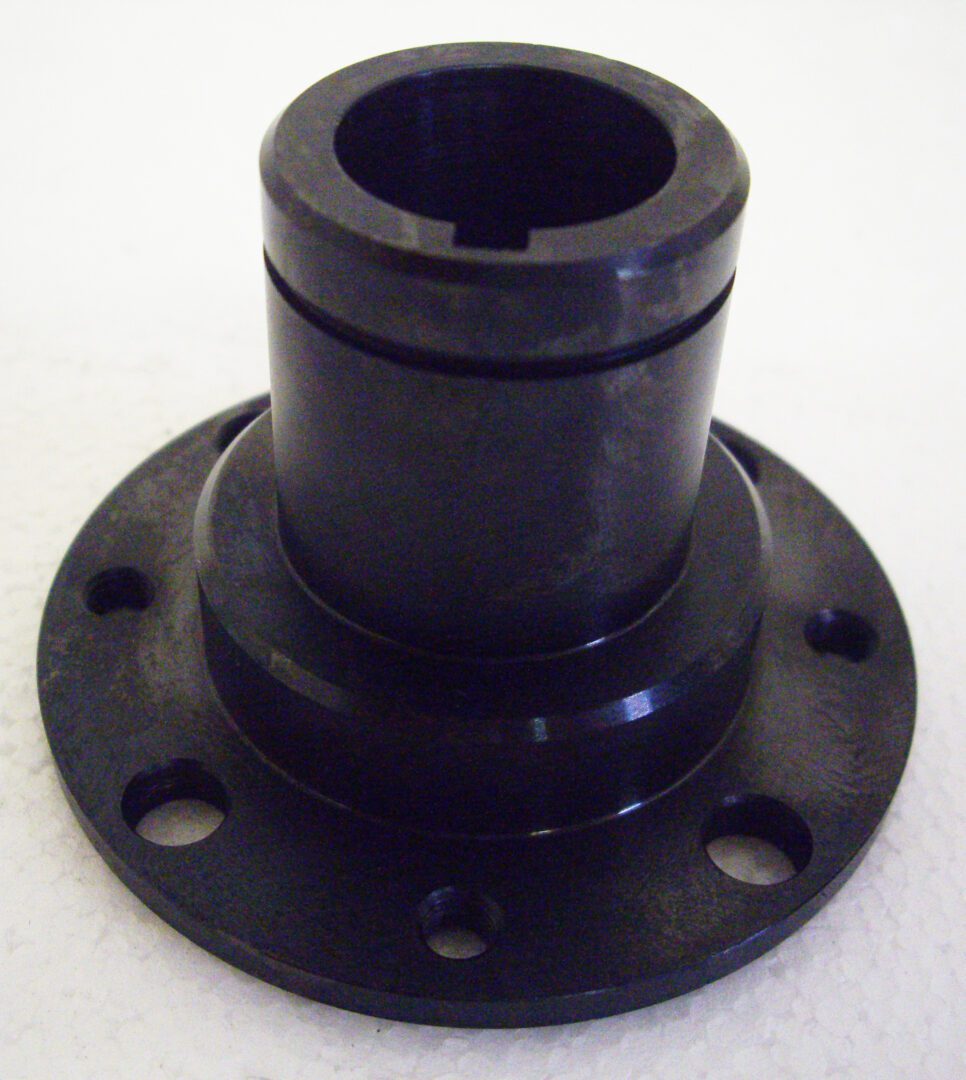 A black plastic part sitting on top of a table.