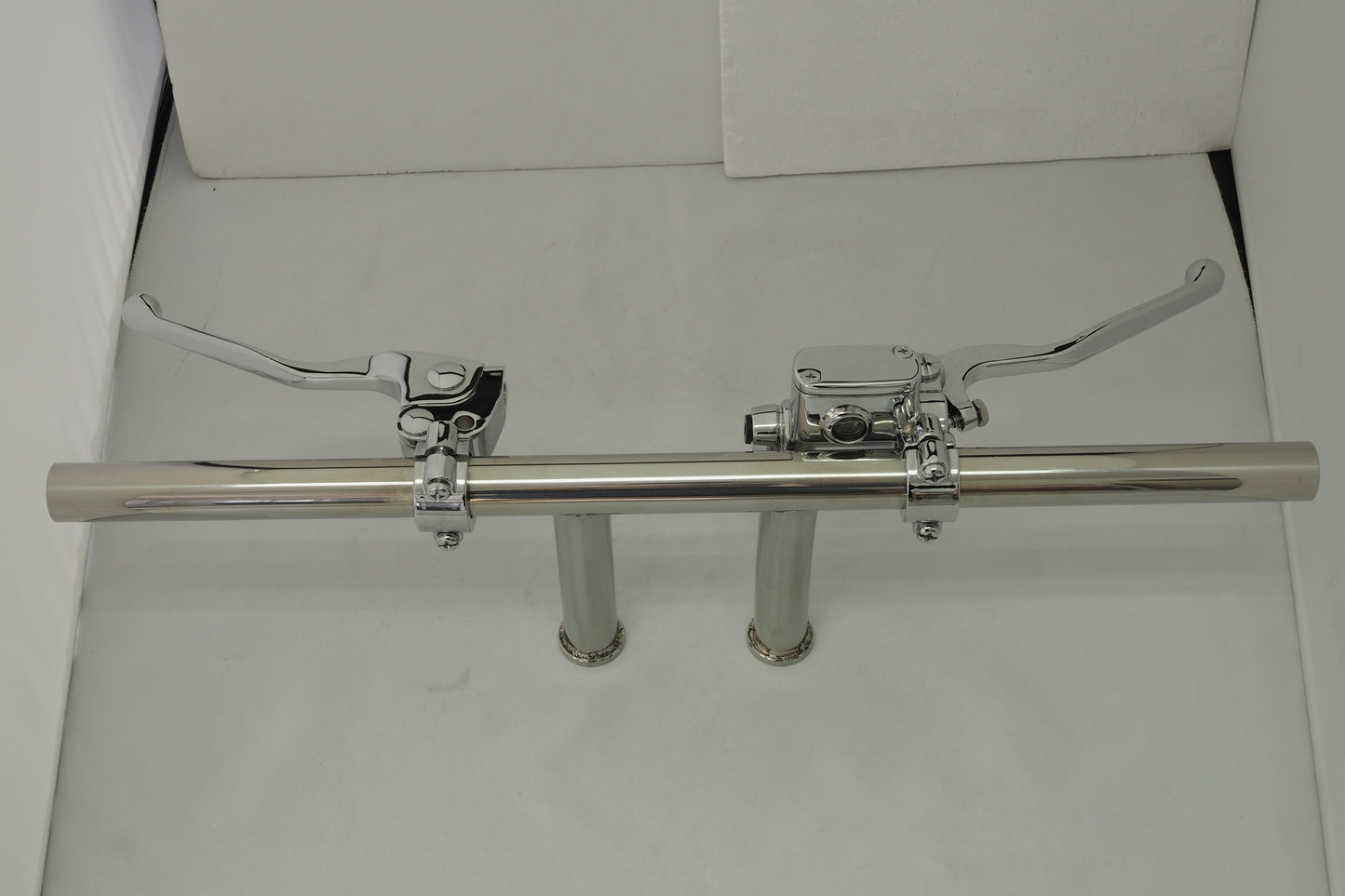 A pair of chrome pipes with two handles on each side.