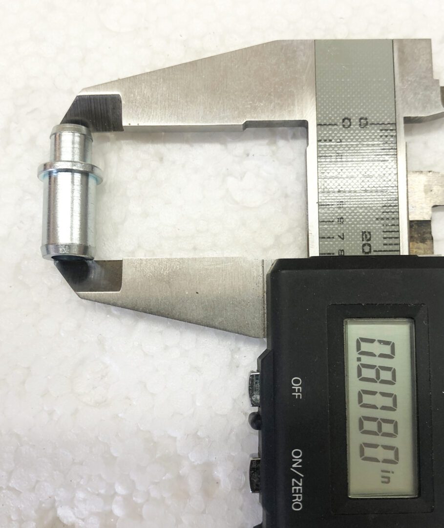 A digital caliper is shown next to a metal object.