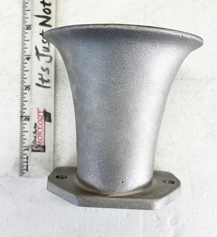 A metal object is shown next to a ruler.