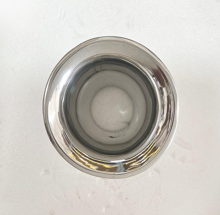 A silver cup sitting on top of a white table.
