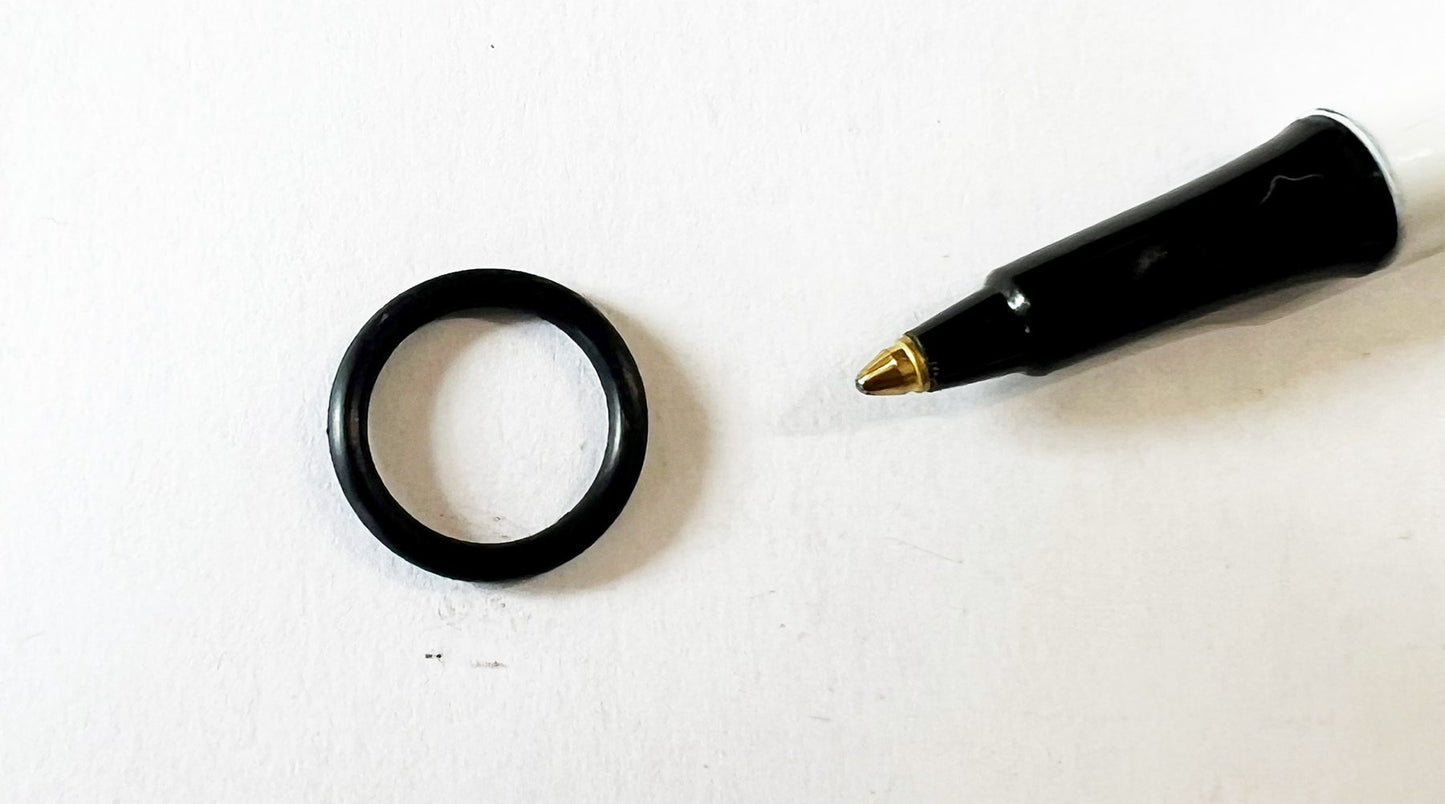 A black ring and a pen on top of a table.