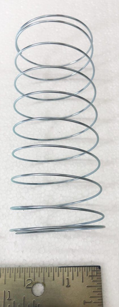 A metal coil sitting on top of a white surface.