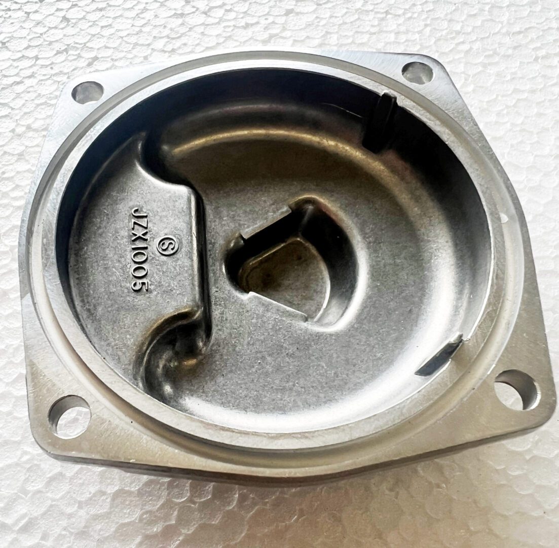 A metal object sitting on top of a white surface.