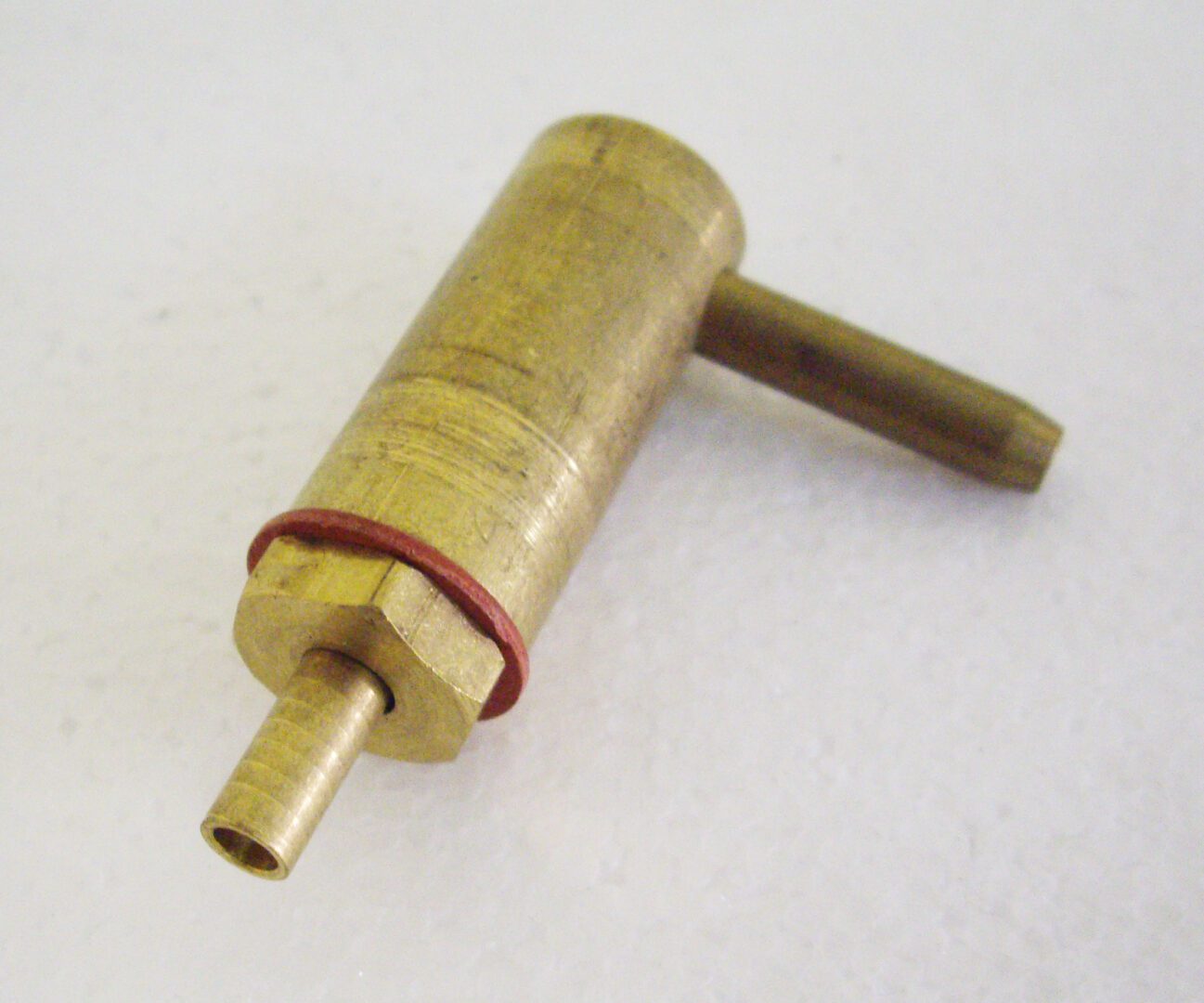 A brass tube with two red lines on it.