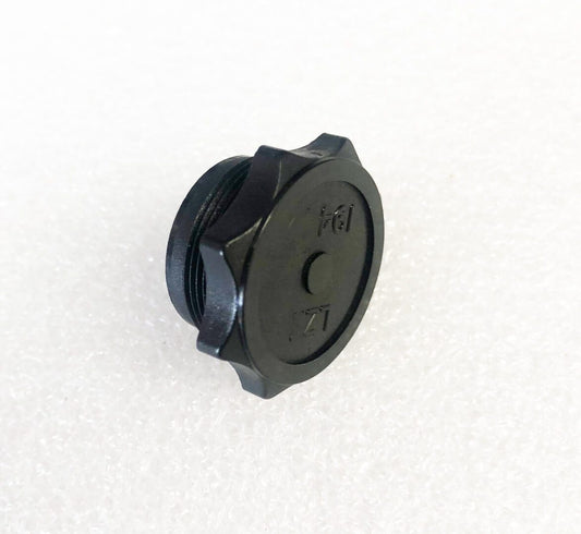 A black plastic cap sitting on top of a white table.