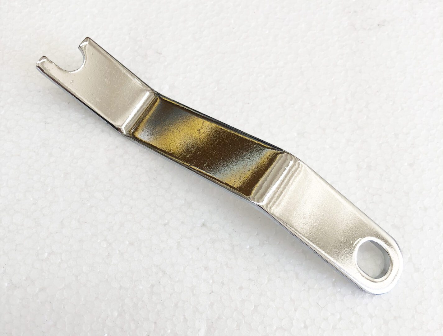A metal object with a brown strip on it.