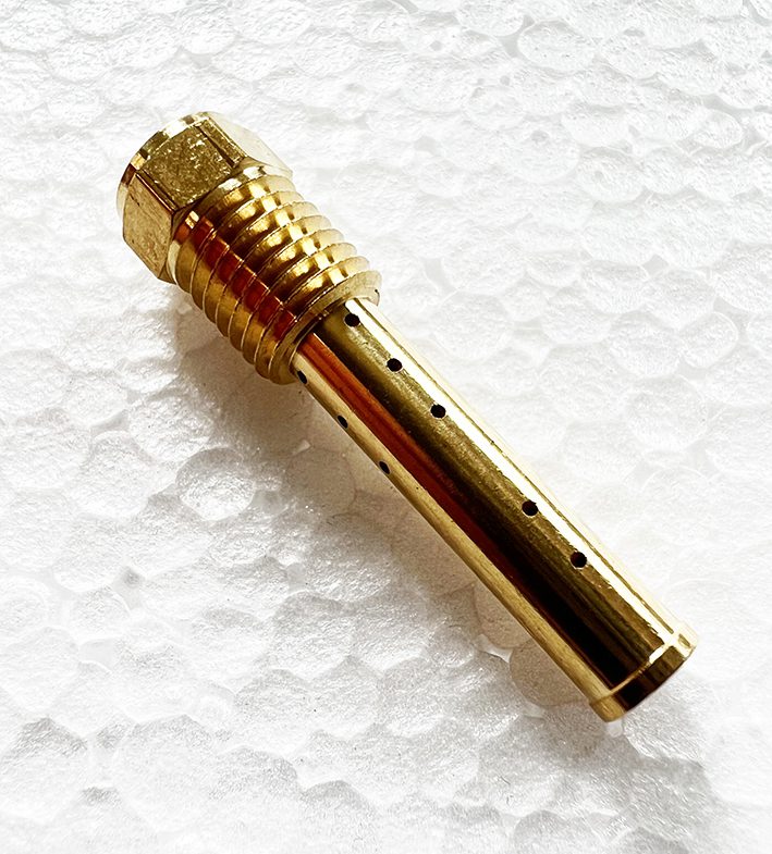 A gold colored metal tube with holes in it.