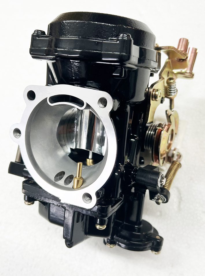 A close up of the carburetor on a motorcycle
