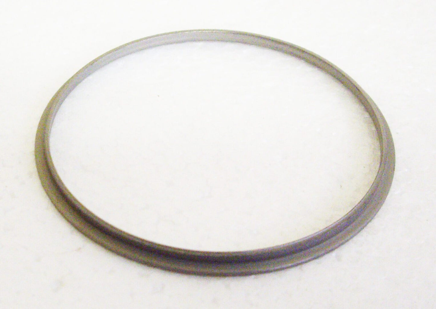 A metal ring sitting on top of a white surface.