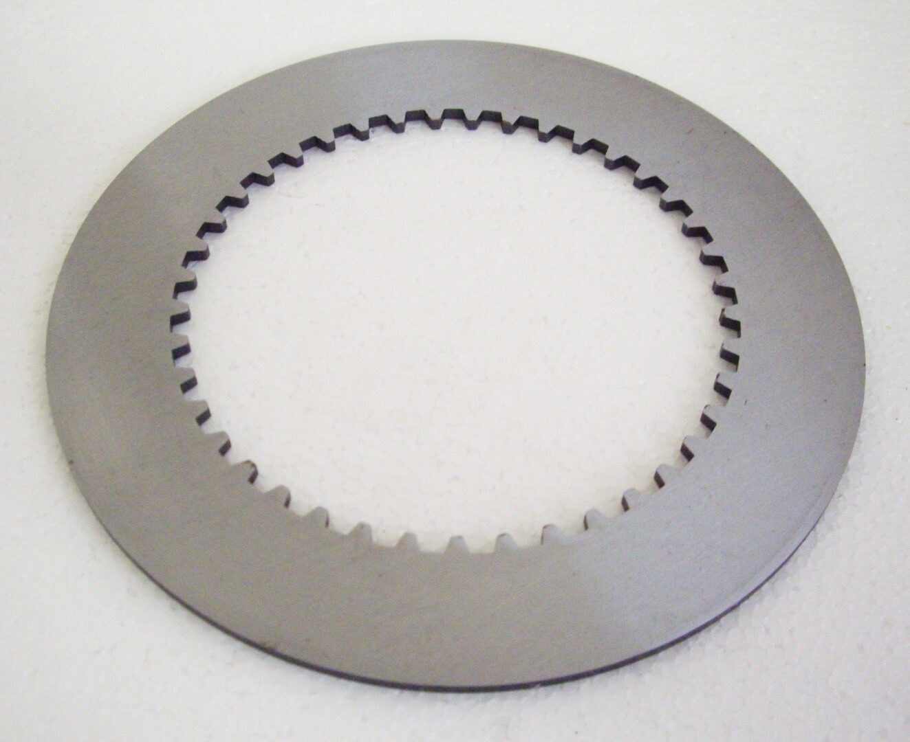 A close up of a disc brake on a white surface