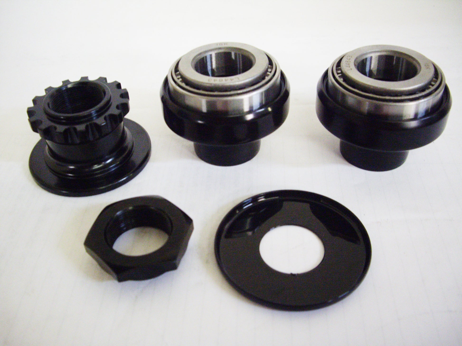 A set of three black bicycle hubs and two black ones.