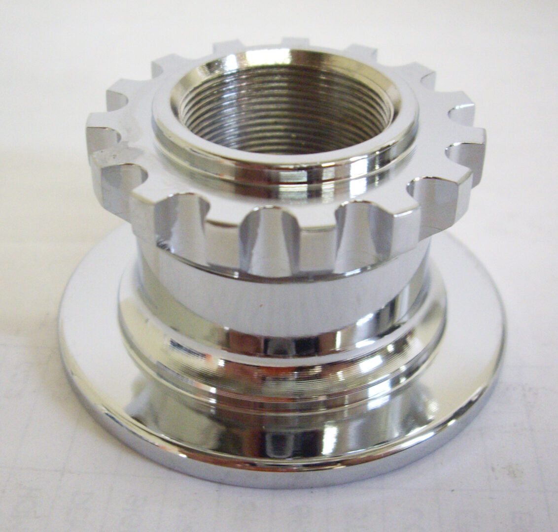 A chrome plated metal part with a large gear.