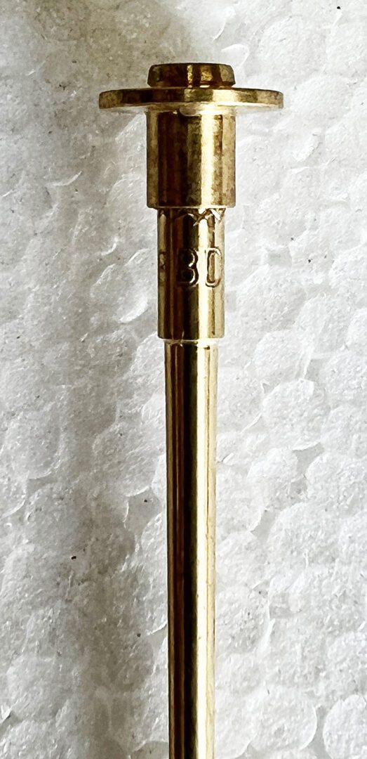 A gold pen sitting on top of a white table.