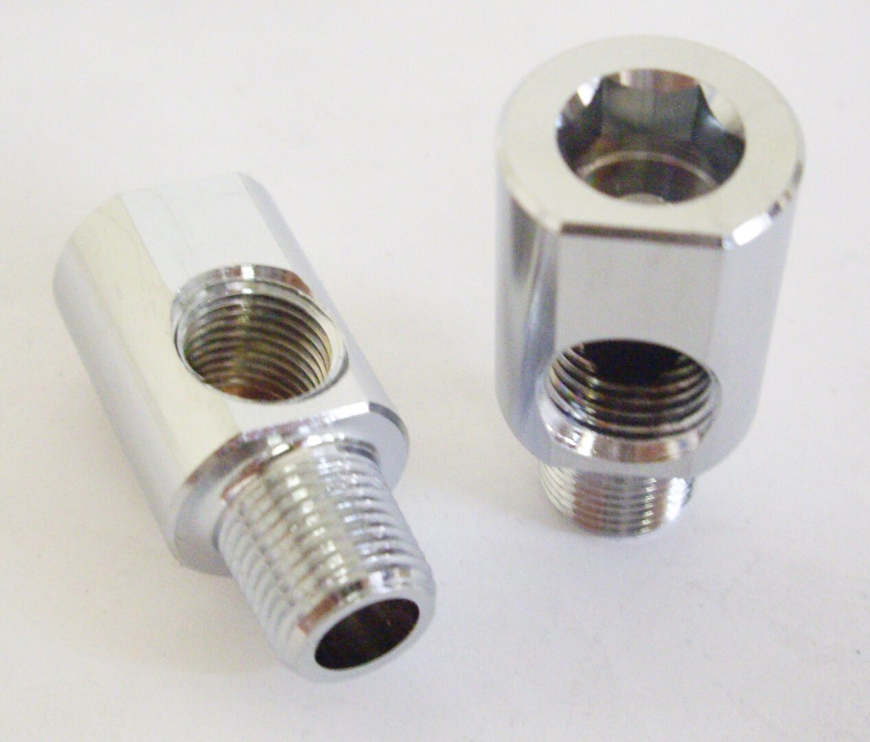 A pair of chrome plated valve stems with an opening.