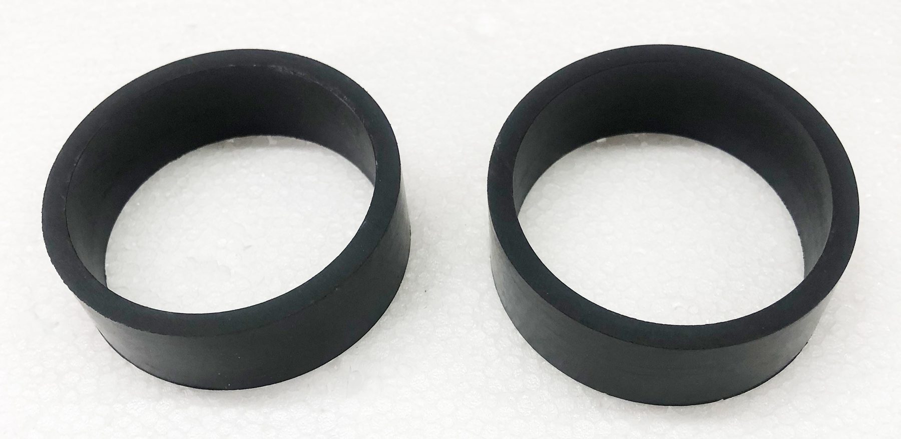 A pair of black rubber rings sitting on top of a white surface.