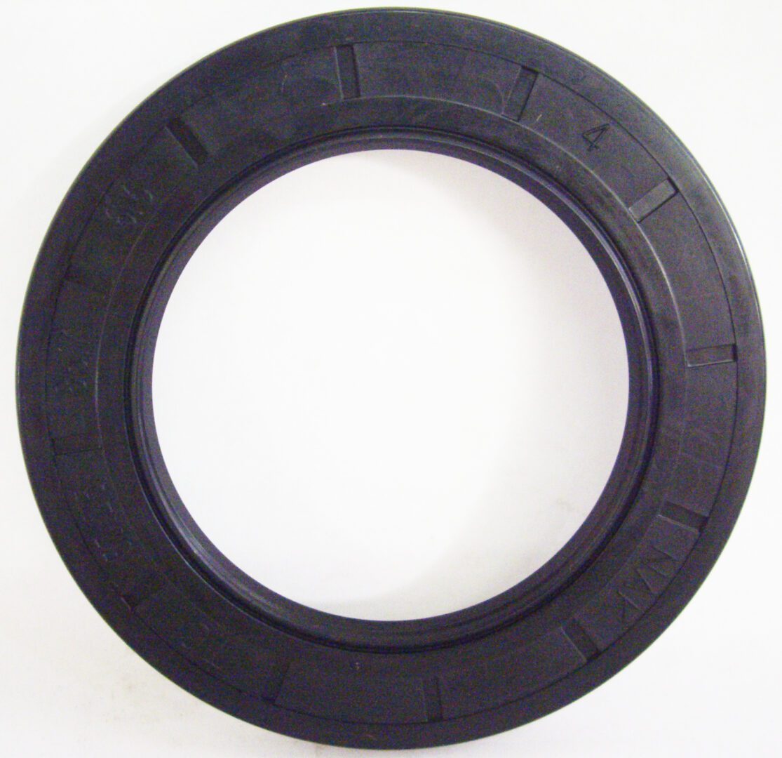 A black rubber seal ring on top of a white wall.