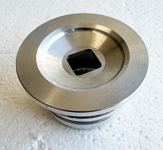 A metal object sitting on top of a white surface.