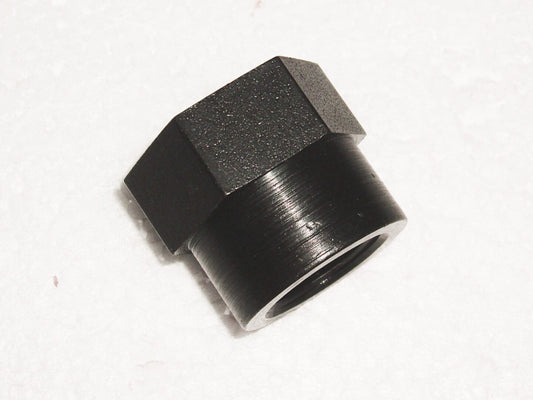 A black nut is sitting on the floor.