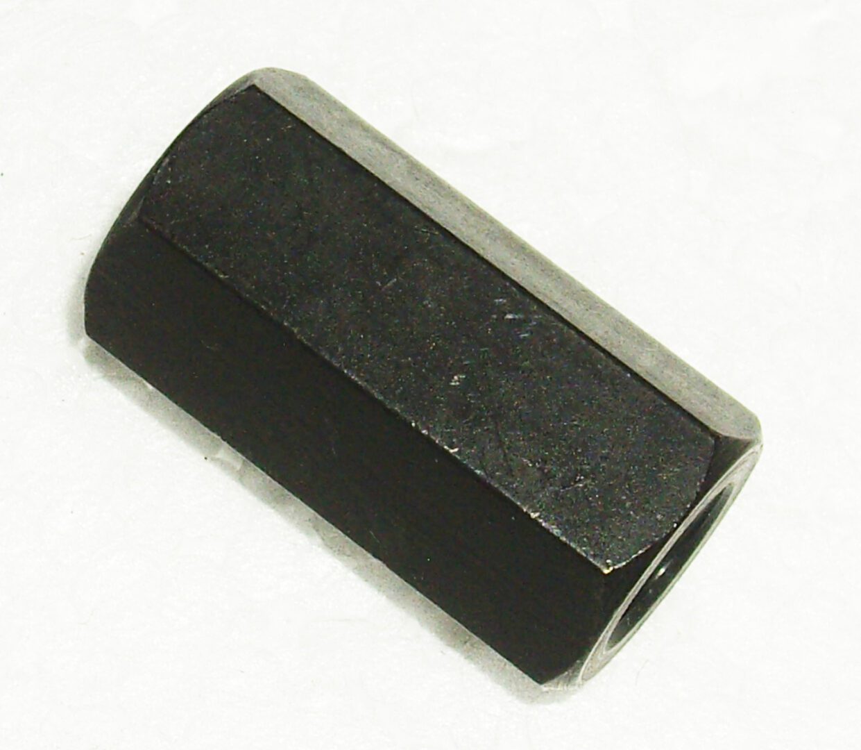 A black nut that is sitting on the ground.