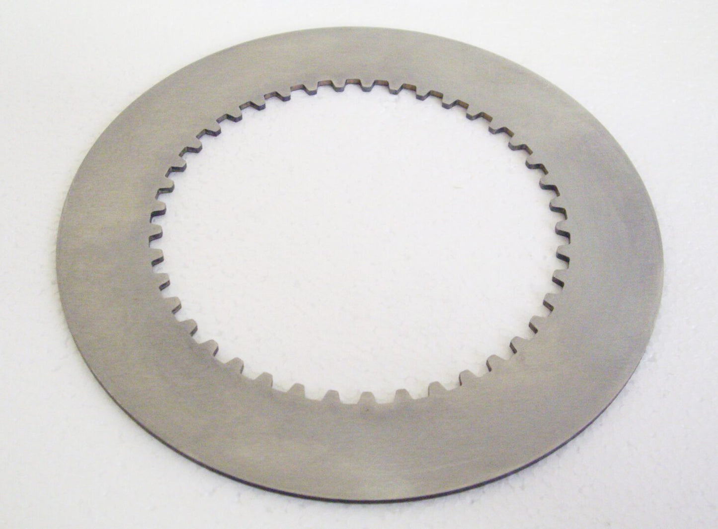 A close up of a disc brake on a white surface