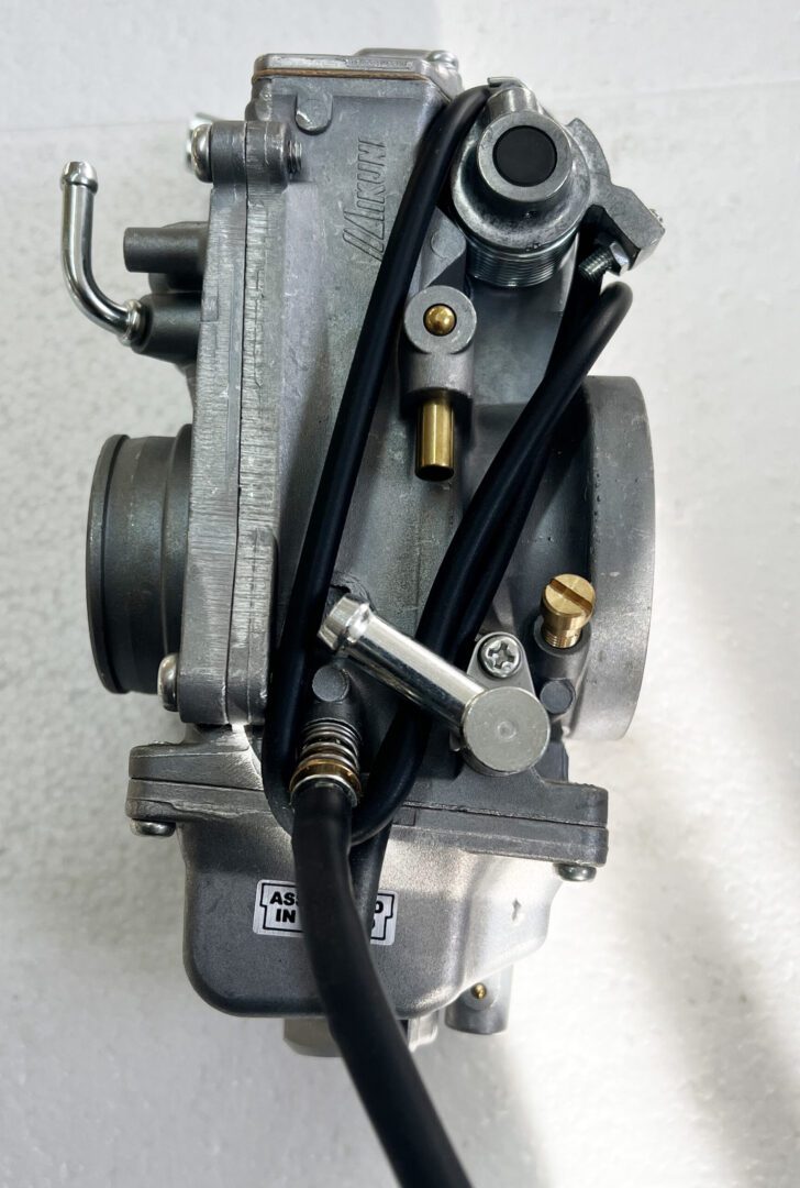 A close up of the carburetor on a motorcycle