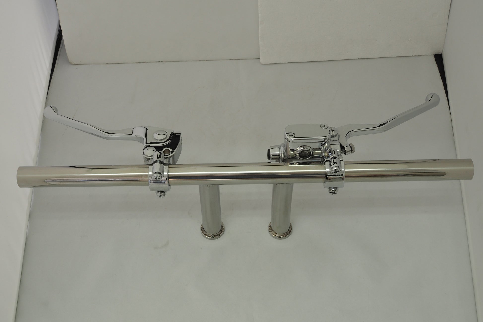 A pair of chrome pipes with two handles on each side.