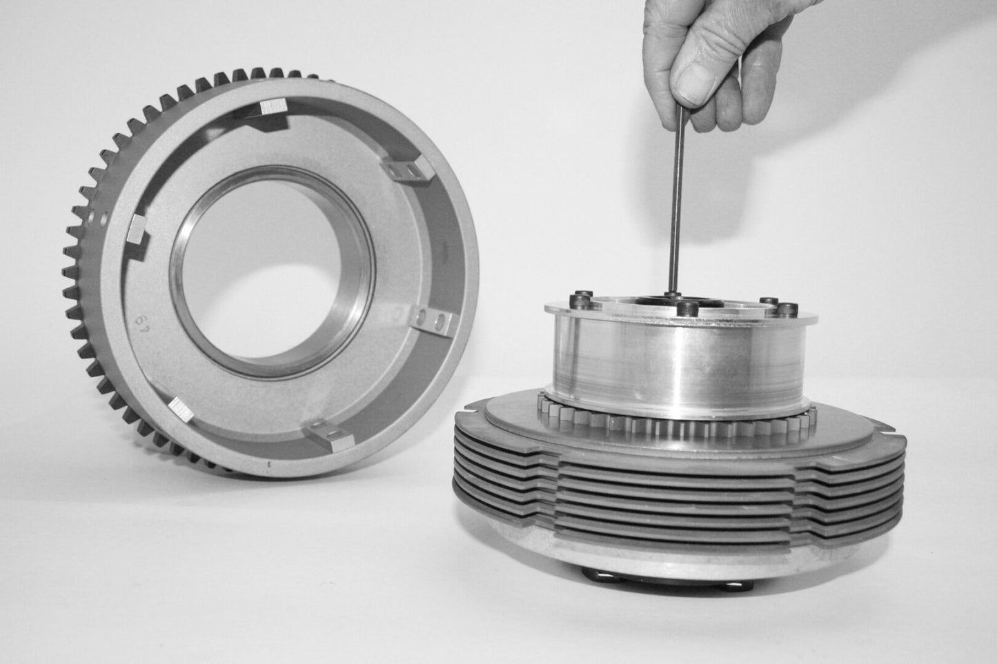 A person is holding the gears of an engine.