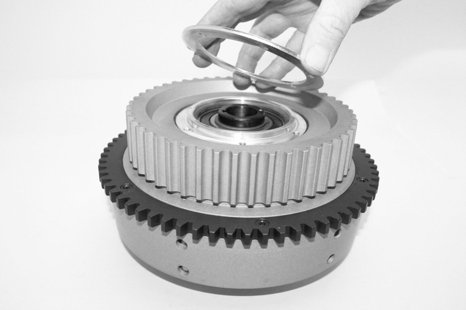 A person is holding the gears of an engine.